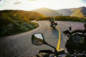 Two motorcycles on winding road - one over yellow line