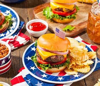 Grilled hamburg and chips on a red, white and blue plate