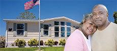 A couple hugging with mobile home behind them