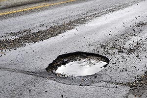 A pothole in a motorcycle's path