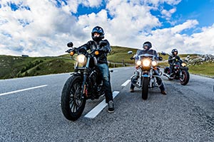Three bikers riding staggered down a road