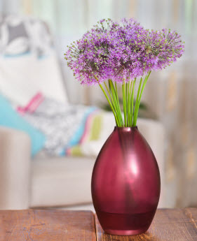 A vase of fresh purple flowers sitting on a table