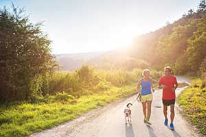 Couple walking on trail with their dog