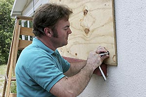 A mobile homeowner boarding up the window